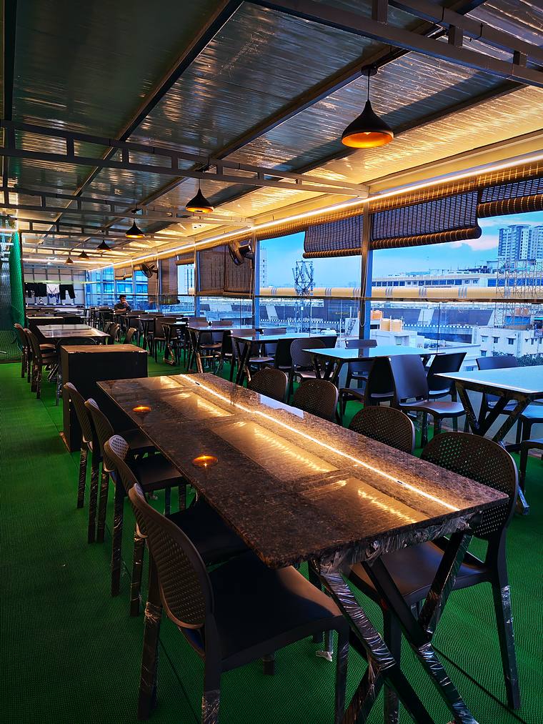 Dining tables in the rooftop café lounge — Vaikuntum Elite Co-Living